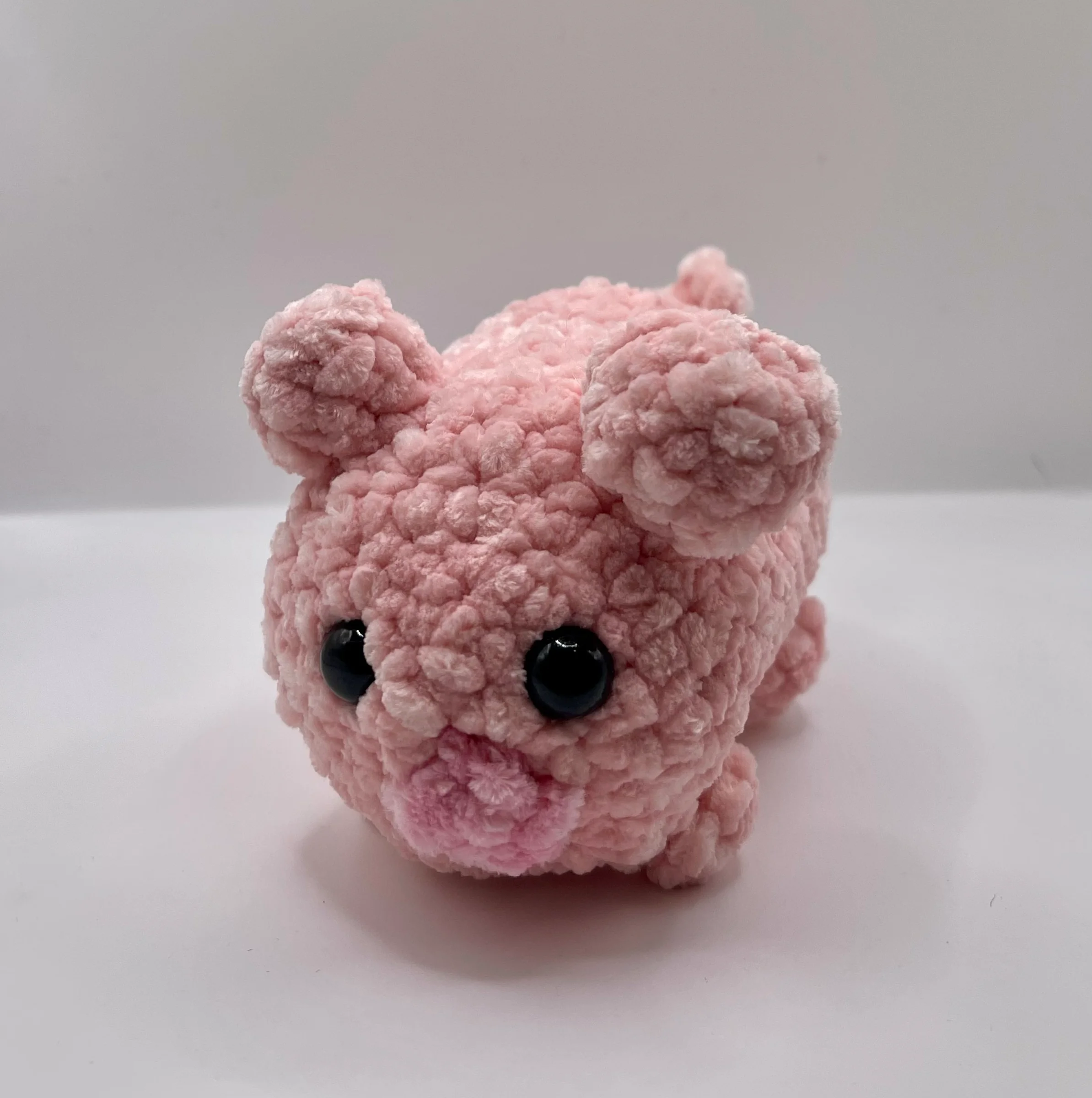 Meet Piggy, a round little friend who is always looking for a cozy spot to take a quick nap! Crafted from ultra-plush pink yarn, this chunky cutie is designed for maximum hugs and smiles. He is officially ready to roll into your home and join your plushie family.