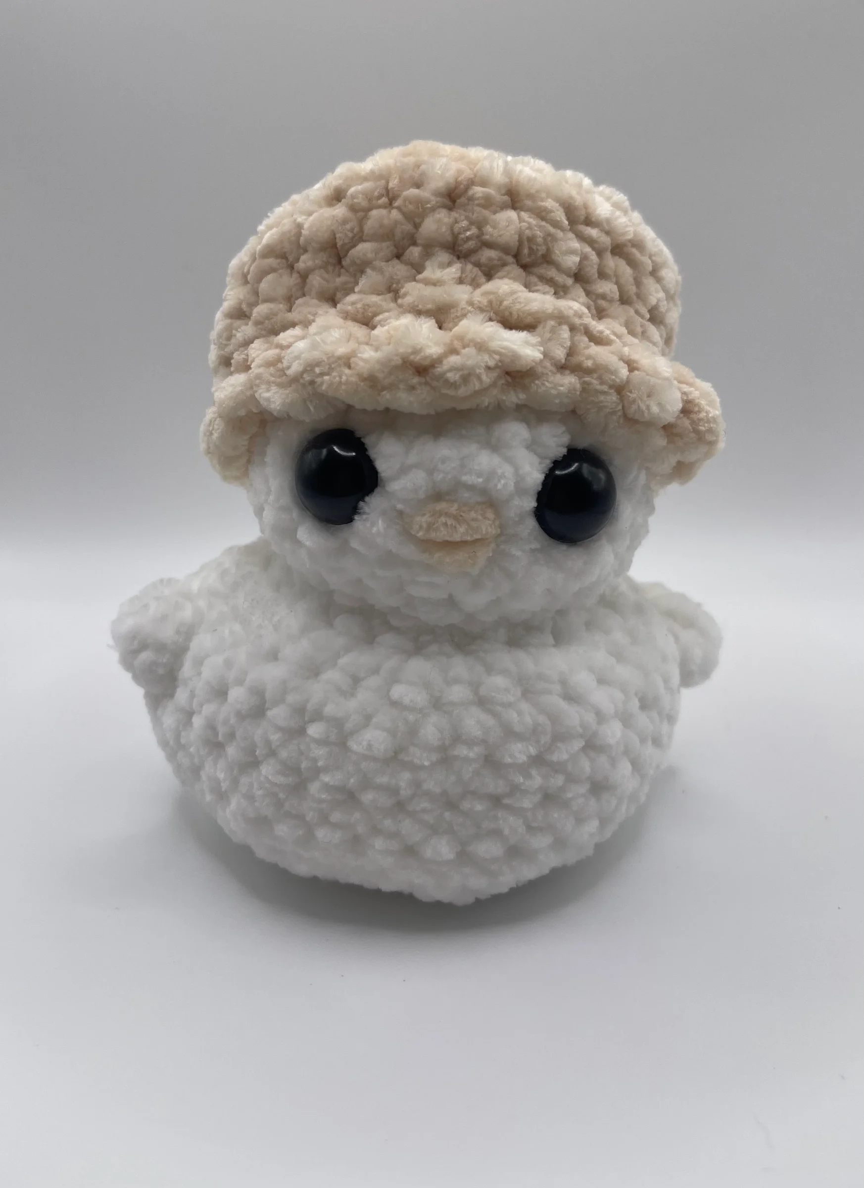 Made form ultra soft white yarn and a soft yellow beak styled with a pale yellow bucket hat.
