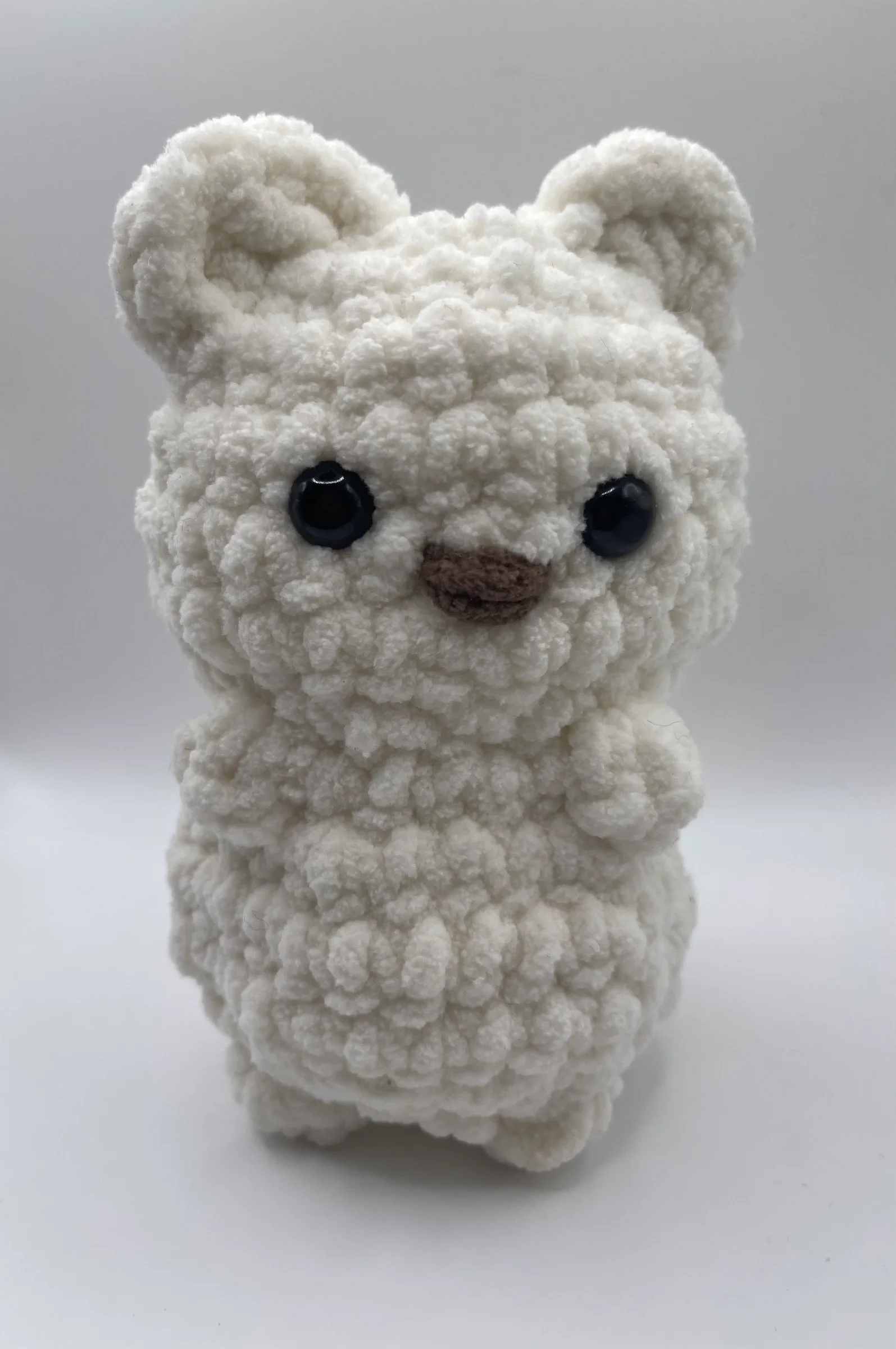 Handmade crochet white bear, made with textured white yarn, and features a sweet brown nose.